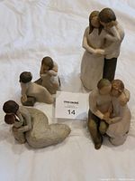 Four Willow Tree resin figurines arranged together, showing their overall size and condition