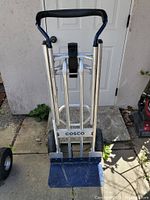 Front view in two-wheel upright dolly configuration showing aluminum frame, foldable blue nose plate and padded handle