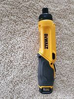 Yellow and black DEWALT cordless screwdriver photographed on carpet surface.