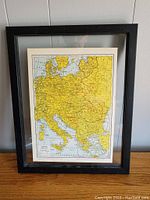 Framed map showing German occupied borders in yellow for WWII era Europe, full view in black frame.