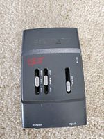 Front view of Fishman G-II preamp showing bass, treble, and volume sliders, and 9V DC power input