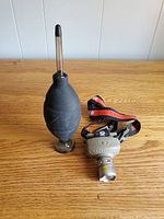 The Cree LED headlamp and camera dust blower set on wooden surface showing the full size and shape of both items.