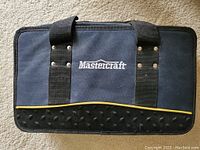 Closed blue and black nylon carrying case with Mastercraft logo on front, zippered closure, and padded black handles.
