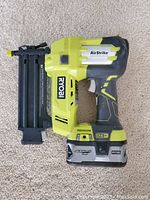 Side view of Ryobi 18V ONE+ AirStrike 18 gauge brad nailer with 18V battery attached, showing overall condition
