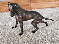 Bronze dog figurine side view showing dog's muscular build and stance