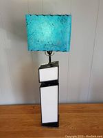 Full view of vintage Pop Graphics lamp shaped as letter 'i' with blue textured mid century modern shade mounted on top.