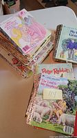 Stack of vintage Little Golden Books with visible titles 'The Lord Is My Shepherd', 'Peter Rabbit', and 'My Grandfather' showing aged condition and golden spine design.