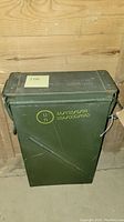 Front and side view of the vintage military ammunition box with the latch and handle visible, showing yellow stenciled military markings