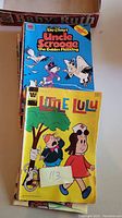 Photo showing Little Lulu comic with nurse on cover and Walt Disney Uncle Scrooge comic titled 'The Golden Fleecing'