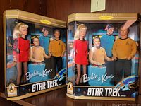 Two boxed Star Trek Barbie & Ken sets displayed side by side, showing full front view of packaging and dolls inside.