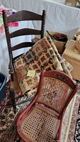 Photo showing both the antique child's rocking chair with caned seat and back, and the handmade patchwork quilt draped over a wooden ladder-back chair.