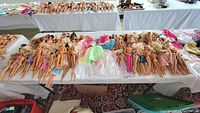 Overview of Barbie and Ken dolls arranged on a table, accompanied by clothing and accessories.