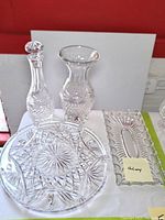 Full grouping of four Galway Irish crystal pieces shown together: decanter with stopper, tall vase, footed round platter, rectangular tray