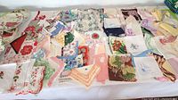 Wide view of assorted vintage handkerchiefs, embroidered and crocheted doilies, and napkins in various colors and patterns.