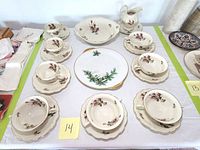 Full set of Rosenthal Pomador china teacups, saucers, bouillon cups, plates, and bowl displayed together with a Tirschenreuth Christmas plate in the center, all on a white tablecloth.