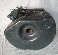 Full view of the dark gray metal gas can showing Mercedes star logo, concave center, and manufacturer markings