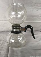 Side view of the assembled miniature Silex/Pyrex vacuum coffee maker showing both glass globes and handle.