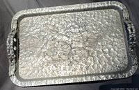 Top view of the rectangular hammer textured tray with floral design and carved handles