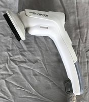 White Rowenta Ultra Steamer handheld fabric steamer with attached white brush and visible water reservoir section