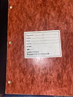 Front cover of a laboratory research notebook showing label with fields for Department, Subject, Name, and Address, indicating these notebooks are specialized for scientific use.