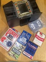 Photo of card shuffler, 4 decks of cards, and poker chips box