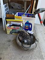 Image showing resin fountain with pump and cords, plus boxes containing gardening tools and other items.