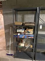Front view of metal shelving unit showing the dent in the middle shelf and shelving dimensions.