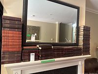 Overall view of multiple maroon and orange Lenin volumes on mantle under mirror