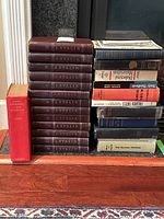 Full group of books arranged in three stacks against fireplace