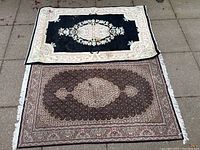 Photo showing both carpets side by side, black carpet on top, brown carpet below, to display overall size and design comparison.