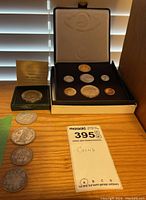 Overall view of velvet coin case, green box, loose coins and MaxSold tag