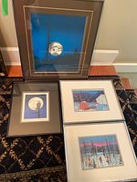 Four framed First Nations prints laid on the floor showing scenes including Roy Vickers Eagle Moon and other outdoor scenes.