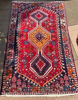 Full rug laid out on ground showing geometric medallion design and border