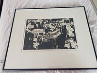 Full view of the framed black and white art print showing abstract shapes on dark background, surrounded by a white mat and set in a thin black frame.