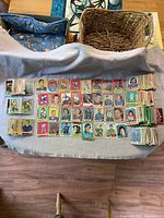 Photo showing a large assortment of vintage NHL hockey cards spread on a grey cloth, with cards organized in rows and piles along the sides.