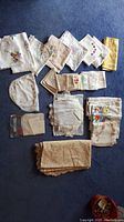 Full lot layout displaying various embroidered napkins, tablecloths, doilies, and linens.
