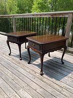 Pair of solid cherry Harden Chippendale end tables on a wooden deck, showing the top and side views with natural sunlight highlighting the polished wood finish and detailing.