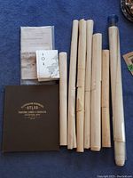 Overview of hardbound atlas, rolled maps in paper tubes and plastic tube, folded pamphlets
