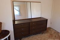 Front and angled front photo of 9-drawer dresser with attached mirror showing layout, drawer fronts, and mirror size.