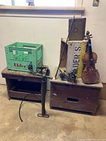 Wide shot showing all items in the lot on wooden crates and bench, including the Elder's pop bottle case, wooden cigar box, fiddle, tire pump, and wall sconces.