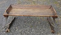 Top view showing the rectangular wooden seating surface with raised edges and aged patina.