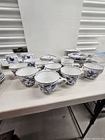 Photo showing multiple Blue Danube porcelain cups with blue floral designs.