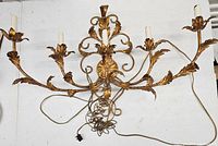 Full view of large ornate vintage brass or copper wall light fixture, showing its wide horizontal span and detailed leaf design arms.