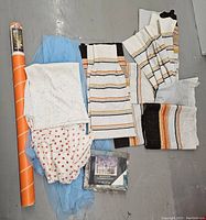 Overall lot showing window film, curtains, and fabric pieces laid out on floor