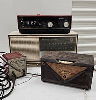 Photo of four vintage electronics items including National Panasonic radio, Silvertone radio, General Electric clock, and Silver Beauty charger
