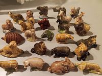 Photo of 23 various vintage Wade ceramic animal figures displayed on a table surface with visible variety of animals and natural colors.