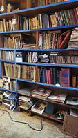 Two shelves fully packed with books, some stacked horizontally, others vertically.