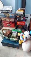 Photo showing stacked board games including Rummikub, Password, Scrabble, Simply Suspects, Speedy Graffiti, poker chips, and a Donald Duck plush toy on a tiled floor.