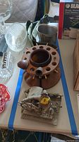 Overall view of pipe holder, pipes, sea captain figurine, and belt holder on table