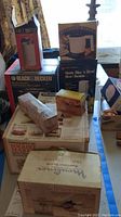 Photo shows boxed Mr. Coffee Coffee Mill, Black & Decker Handy Steamer, Handy Slice & Shred, Hamilton Beach Yogurt Maker, and salt and pepper shakers alongside meat tenderizer in original packaging.